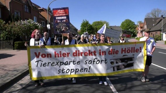 Bei einer Demo in Aurich halten Menschen ein Plakat mit der Aufschrift: "Von hier direkt in die Hölle! Tiertransporte sofort stoppen!" © NonstopNews 