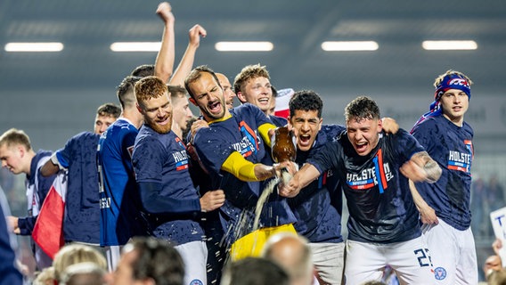 Kiels Spieler feiern mit den Fans gemeinsam den Aufstieg © picture alliance Foto: Axel Heimken